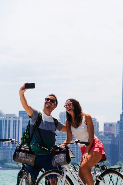 Una coppia in bicicletta che scatta una foto sul lungolago di Chicago