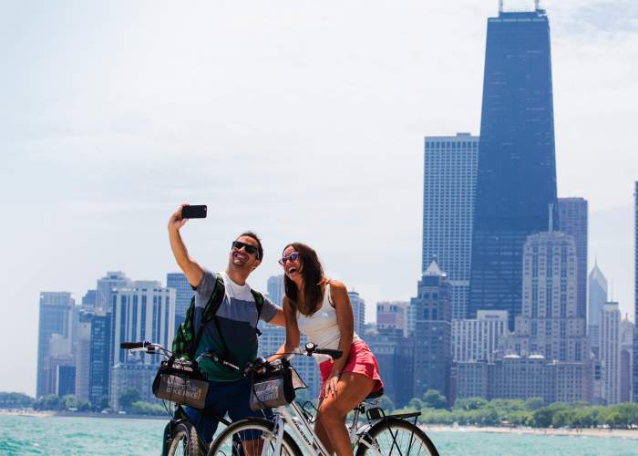 Una coppia in bicicletta che scatta una foto sul lungolago di Chicago