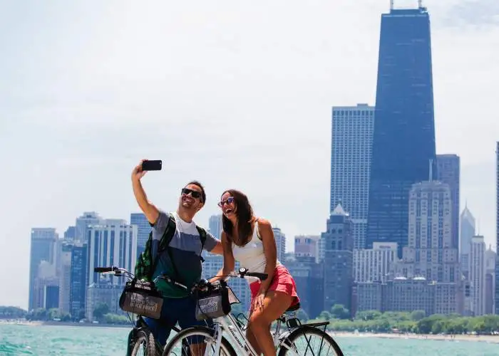 Una coppia in bicicletta che scatta una foto sul lungolago di Chicago