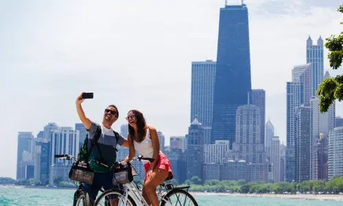 Una coppia in bicicletta che scatta una foto sul lungolago di Chicago