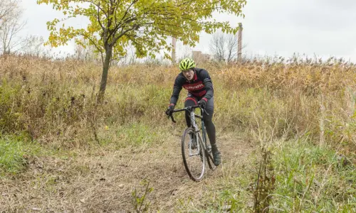 Un ciclista in bicicletta tra l'erba lunga
