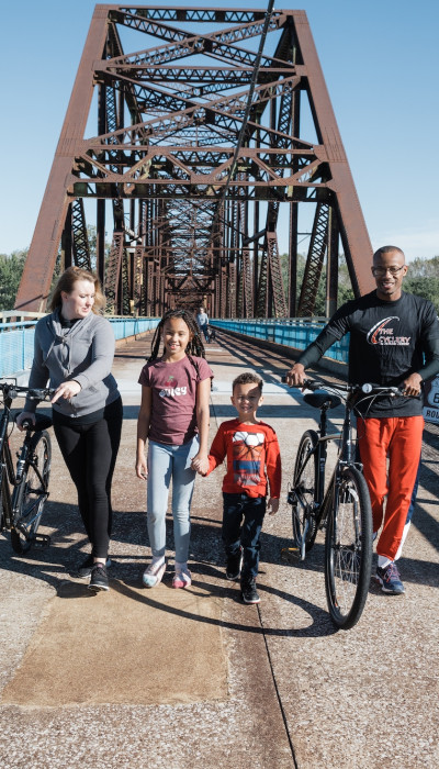 Famiglia con bicicletta su un ponte