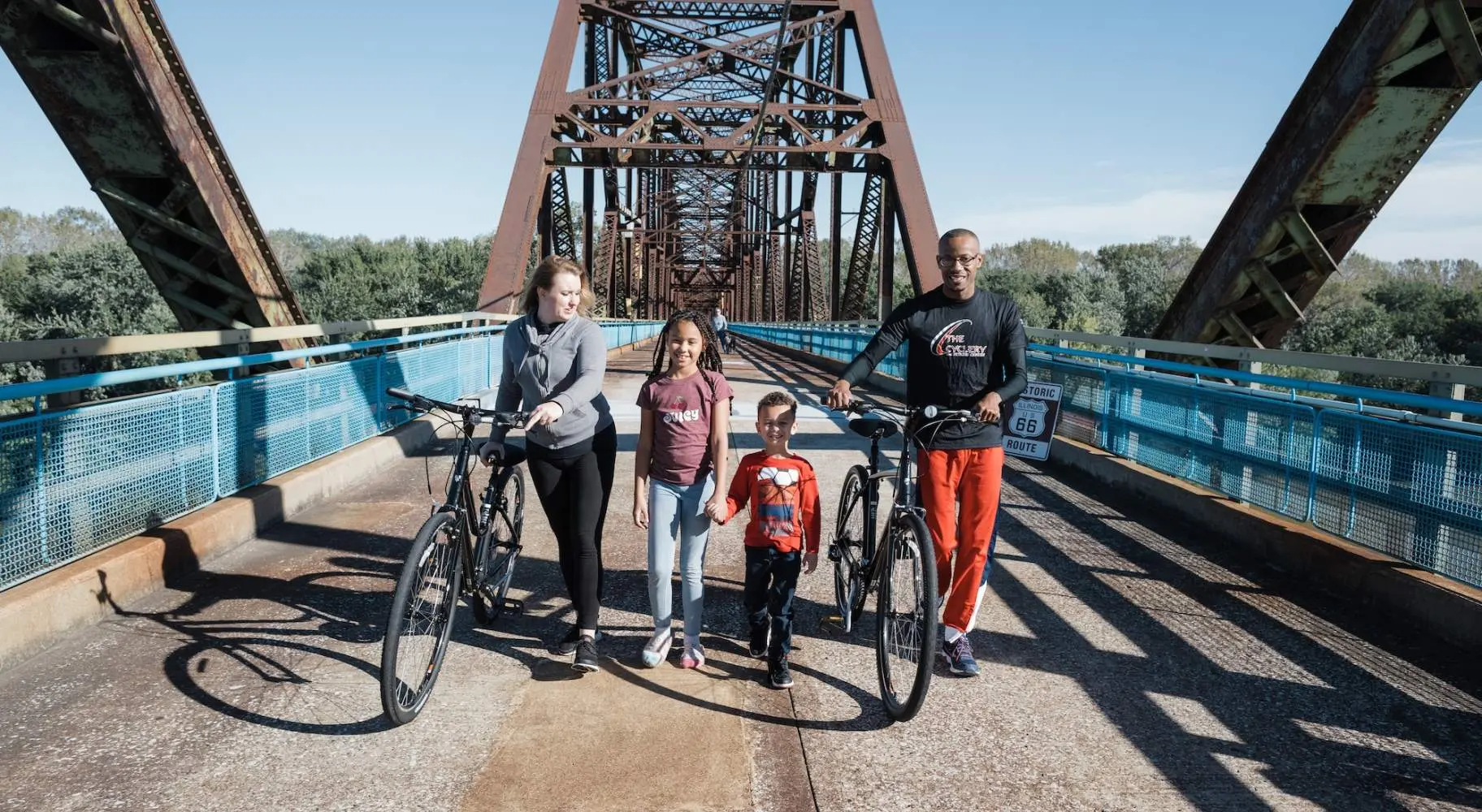 Famiglia in bicicletta su un ponte