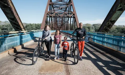 Famiglia in bicicletta su un ponte