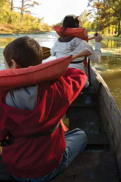 Una famiglia con il giubbotto di salvataggio in canoa lungo un fiume