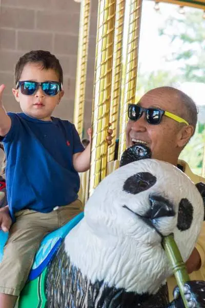 Un bambino e i suoi nonni sulla giostra dello zoo di Brookfield.