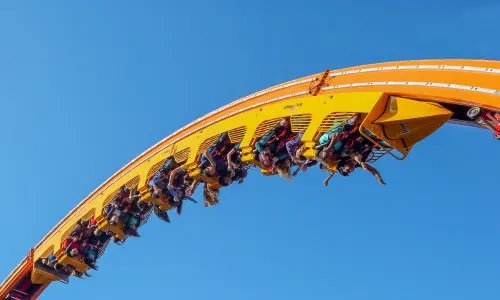 Gruppo di persone sulle montagne russe a mezz'aria. 