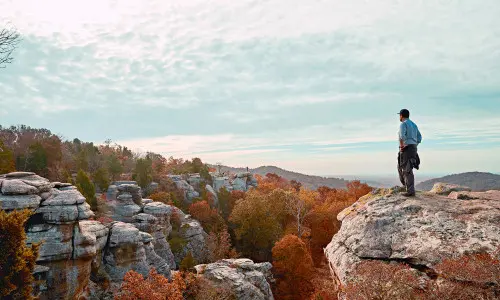 Uomo in piedi in cima a una roccia nel Garden of the Gods
