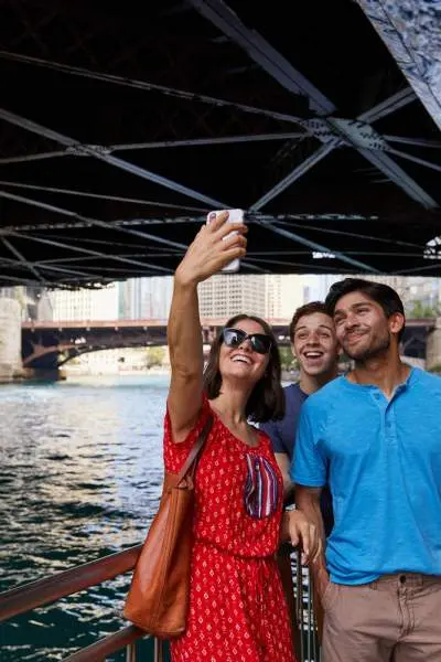 Persone in posa per una foto lungo il fiume sotto un ponte 