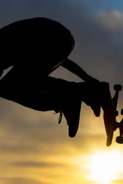 Uno skateboarder salta in aria contro il sole al tramonto in uno skate park di Chicago.