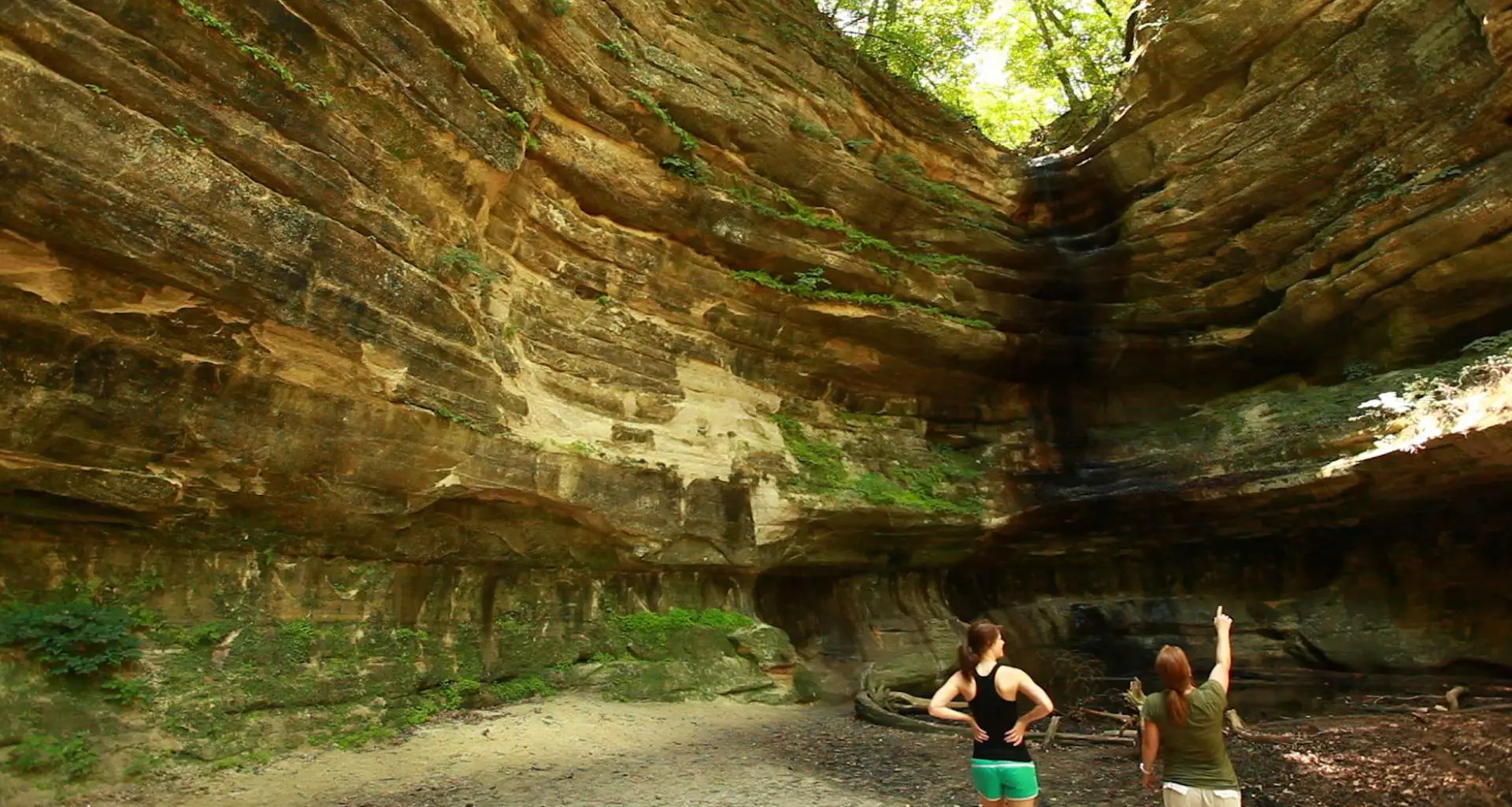 Due persone che guardano la grande roccia che circonda 