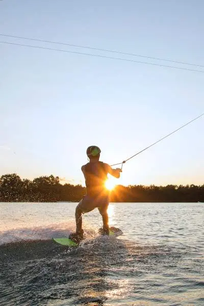 Una persona che fa wake boarding al tramonto 