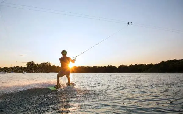 Una persona che fa wakeboarding al tramonto 
