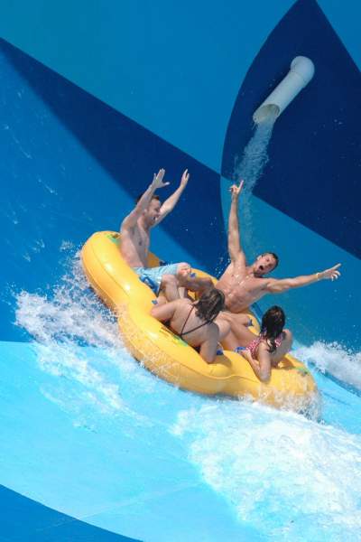Un gruppo di quattro persone in una zattera gonfiabile su uno scivolo d'acqua