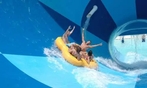 Un gruppo di quattro persone in una zattera gonfiabile su uno scivolo d'acqua