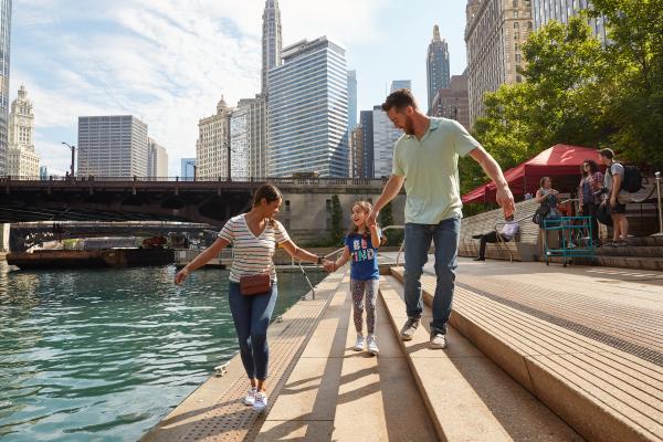 Famiglia che si sveglia lungo un fiume con la città sullo sfondo