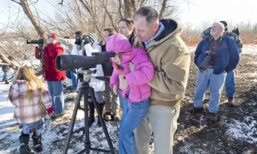 Persone che guardano attraverso l'obiettivo di una grande macchina fotografica
