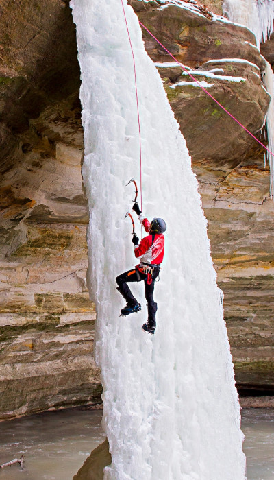 Persona che si arrampica su una cascata di ghiaccio