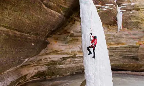 Persona che si arrampica su una cascata di ghiaccio