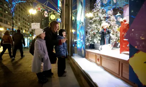Donna e bambini guardano fuori da una vetrina