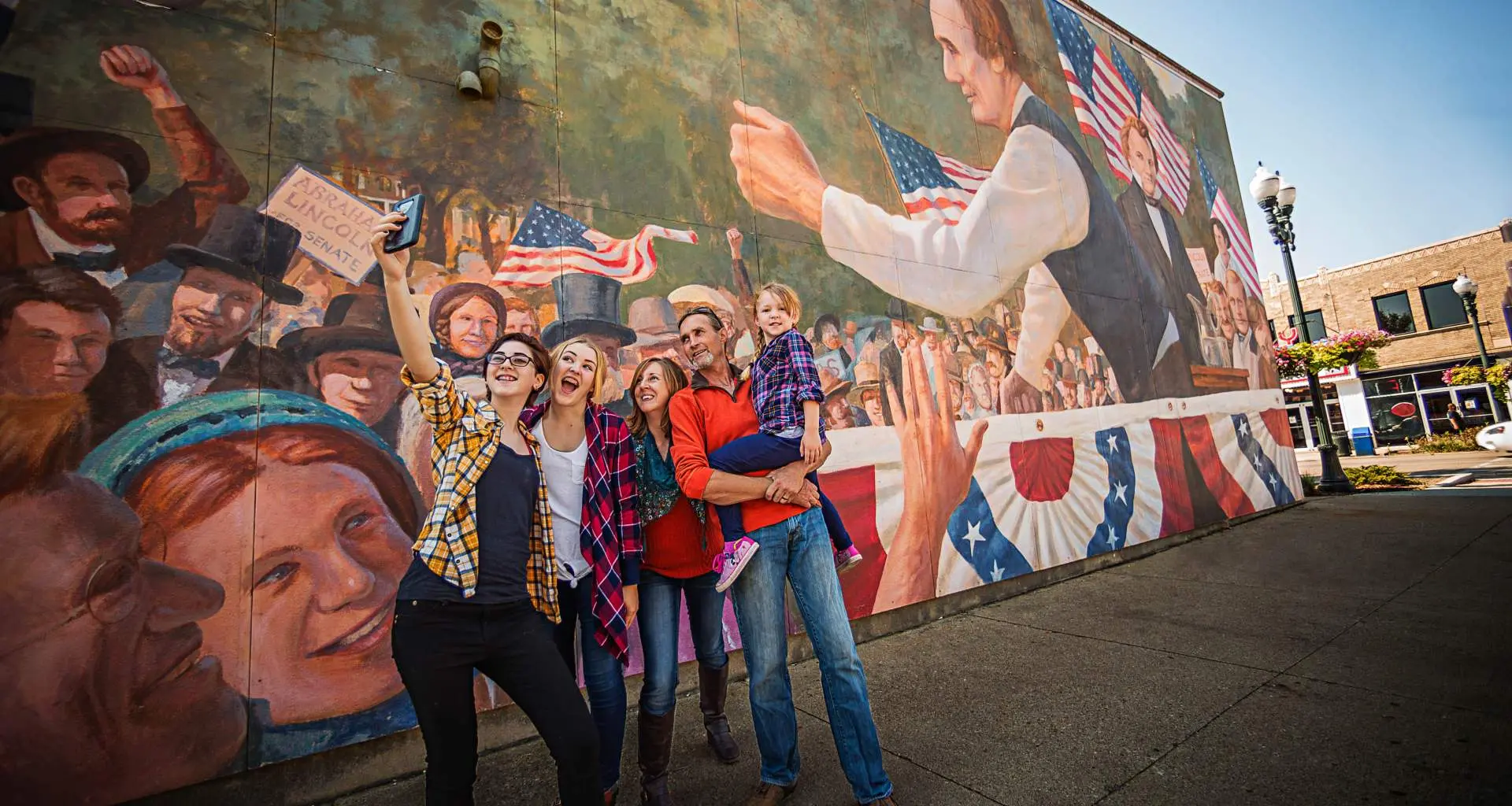 Famiglia che si scatta un selfie davanti a un murale a Ottawa