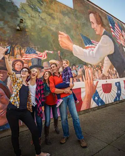 Famiglia che si scatta un selfie davanti a un murale a Ottawa