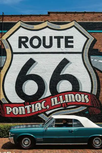 Murale della Route 66 con un'auto Pontiac di fronte.