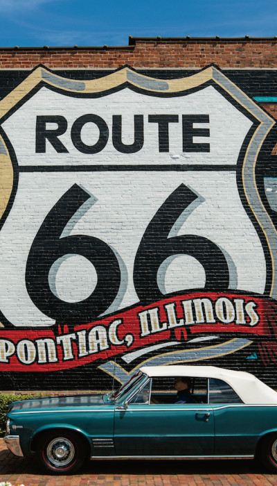Murale della Route 66 con un'auto Pontiac di fronte.