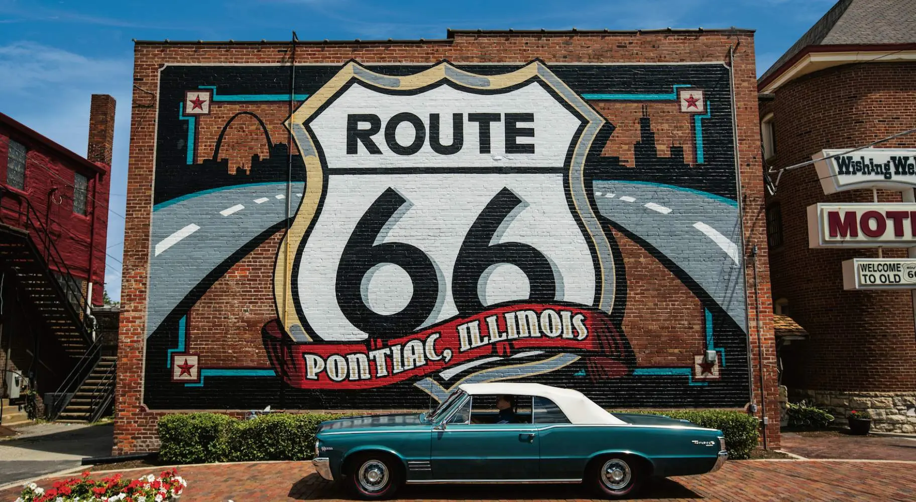 Murale della Route 66 con un'auto Pontiac davanti.