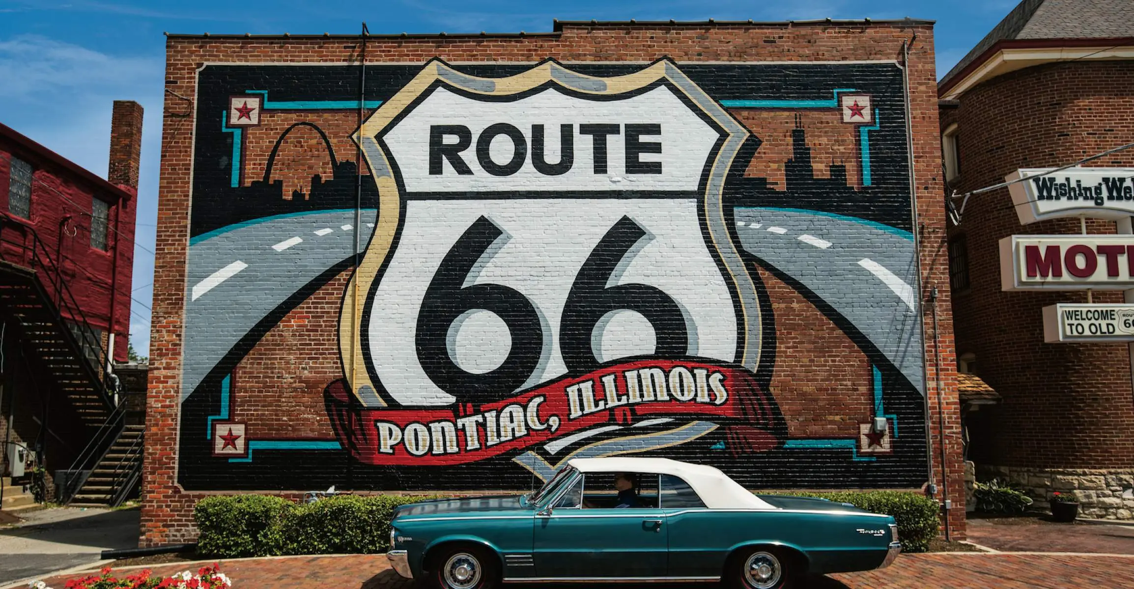 Murale della Route 66 con un'auto Pontiac davanti.