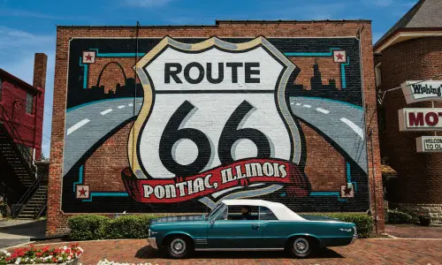Murale della Route 66 con un'auto Pontiac davanti.