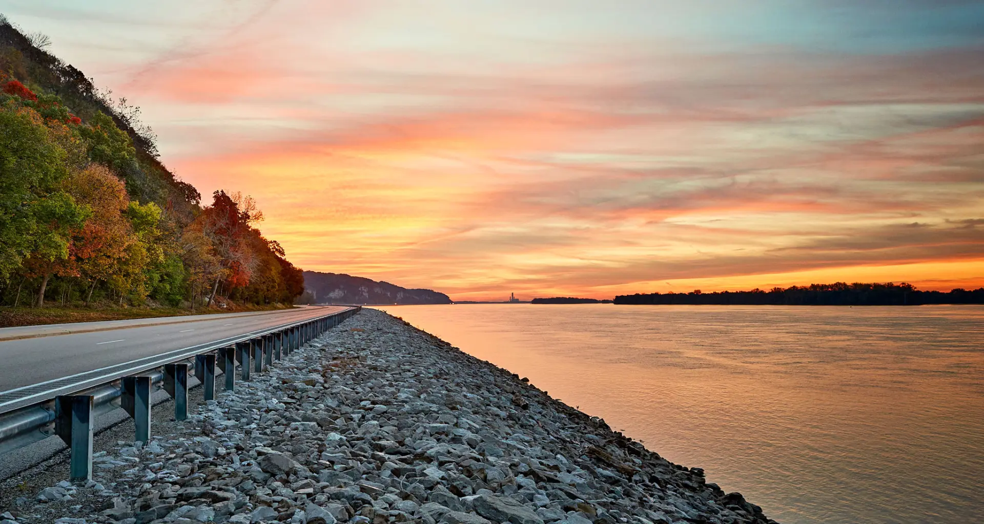 Tramonto sull'acqua e strada lungo il fiume