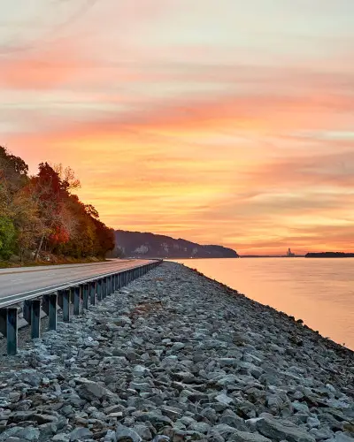 Tramonto sull'acqua e strada lungo il fiume