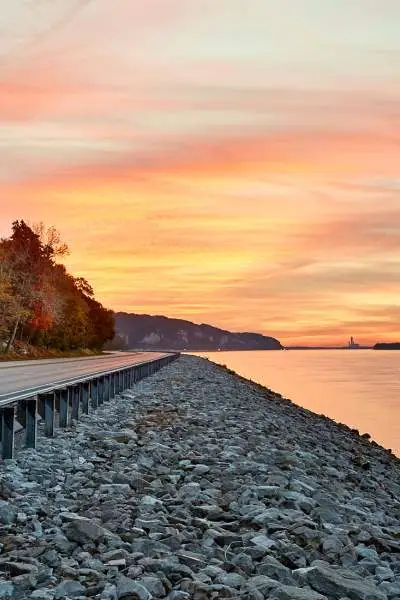 Tramonto sull'acqua e strada lungo il fiume