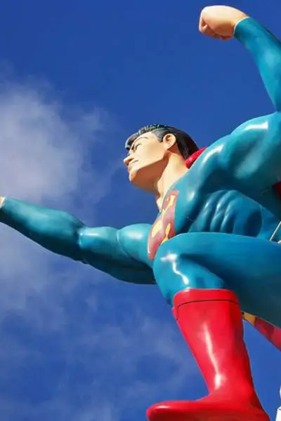 Una statua di Superman contro un cielo blu