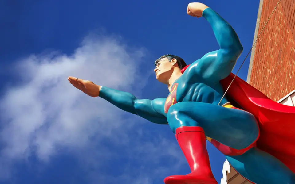 Una statua di Superman contro un cielo blu