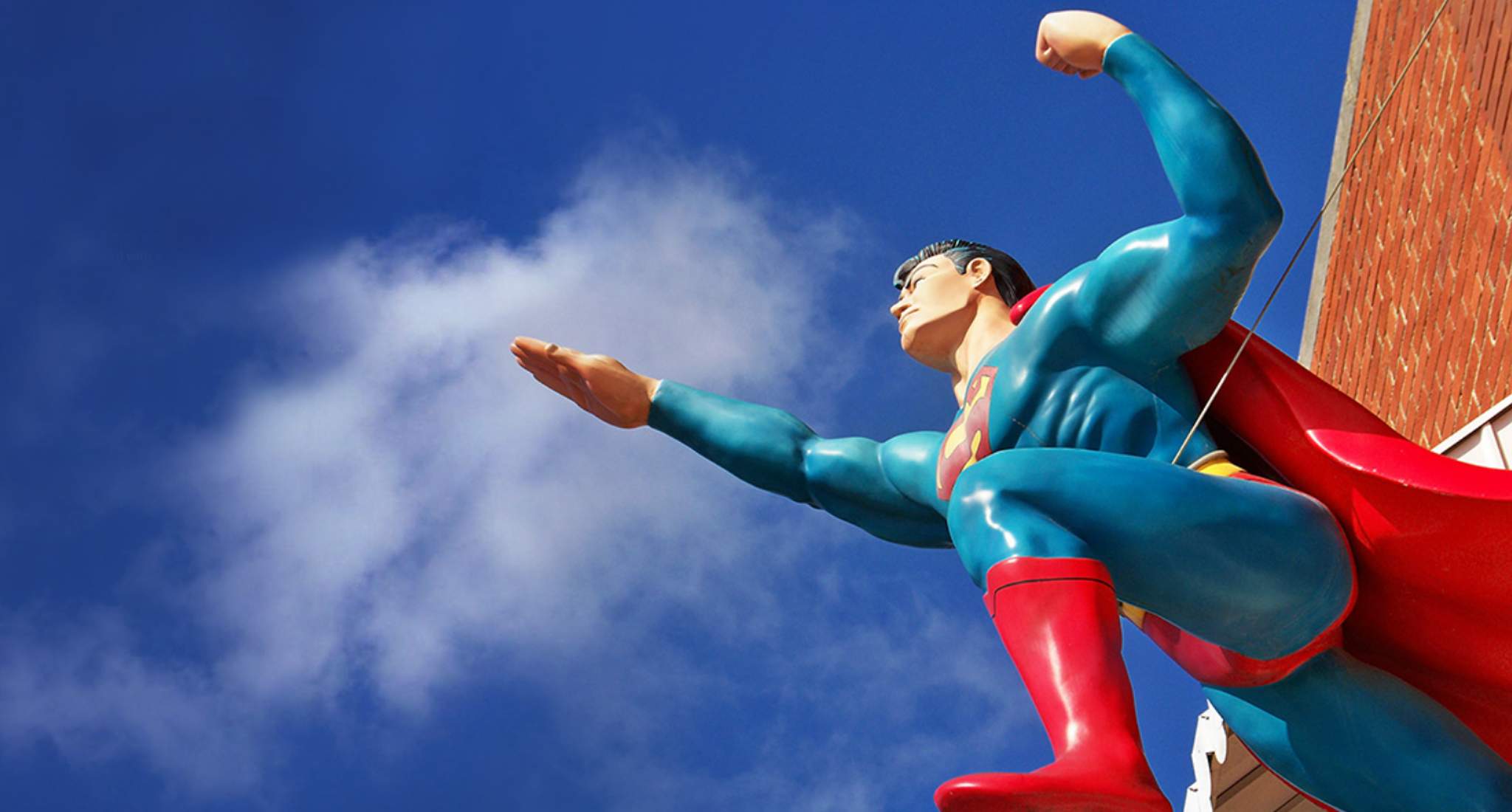 Una statua di Superman contro un cielo blu