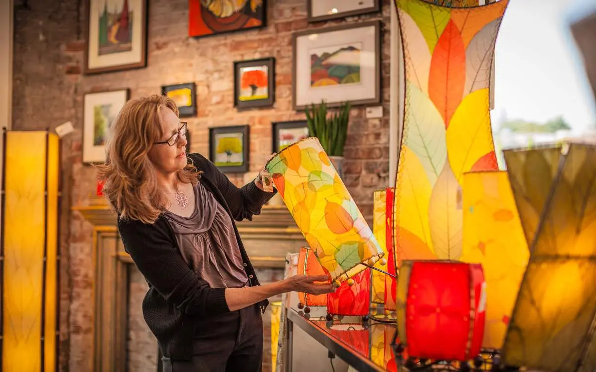Una donna acquista lanterne alla Curtis Frame Back Alley Gallery di Libertyville.